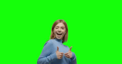Young cheerful caucasian woman showing thumbs up over green screen background Chroma Key. 4k video footage slow motion 60 fps