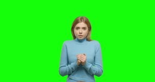Shocked woman open mouth. Shock girl cover face with hands in green studio. Close up of scared female model expression in 4k video footage slow motion 60 fps