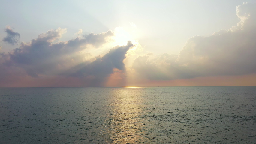 Aerial shot of the sun rising at sea 