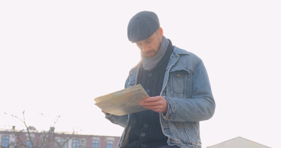 Ypung male traveler with map in the city	