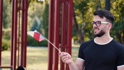 European student is waving the Czech Republic national flag. The flag is on a stick.