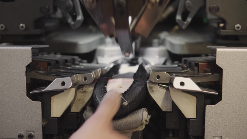 Man use special machine tool for making a shoes. The conveyor on a shoes factory with shoe and sole. Mass production of footwear., an Industrial Video by Volodymyr_Shtun