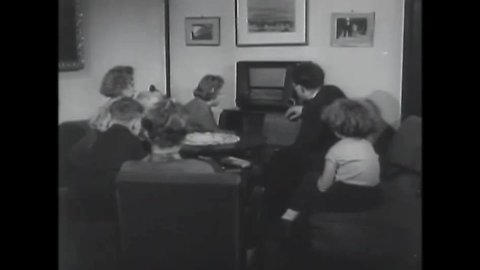 CIRCA 1953 - A somber family listens to the radio.