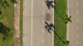 Aerial view of cyclist cycling through an urban road in Cyberjaya City, Malaysia. Zoom out, top down footage.