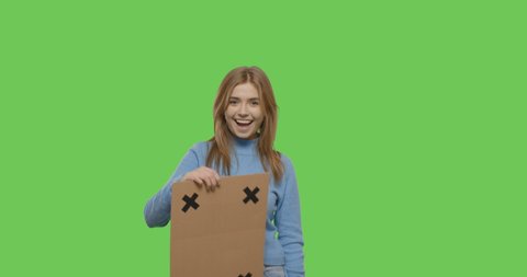 Serious young woman throwing aside placard cardboard with tracking points . Girl having fun with blank sign on Green Screen background , Chroma Key. isolated 4k video footage slow motion 60 fps