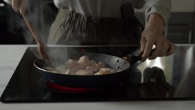 woman roasts a chicken in a frying pan