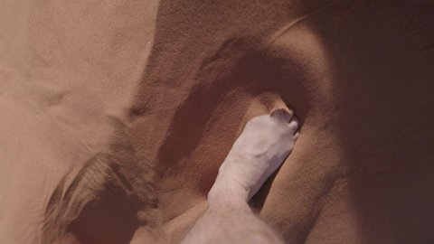 Slow motion point of view shot of feet walking on the red sand of a dune in the Namib desert.