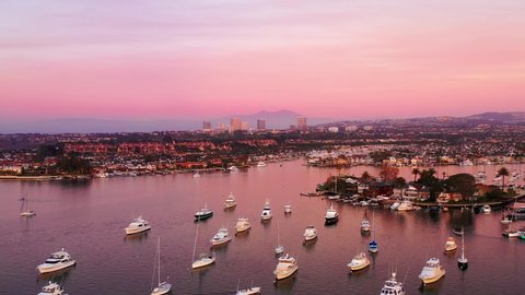 Aerial view of boats, yachts and waterfront homes in Newport Beach, Orange County, California over harbor just after sunset during twilight.
