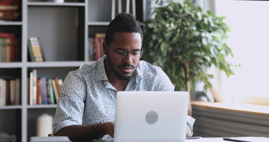Shocked frustrated african mixed race business man student feel stressed look at computer screen worried of problem read bad online news receive failed exam results concept sit at home office table Royalty-Free Stock Footage #1044264613