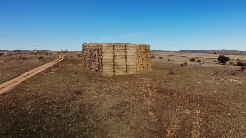 Wheat straw bales stacked on huge pile (drone view)
