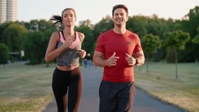 Front view of young couple jogging in the park