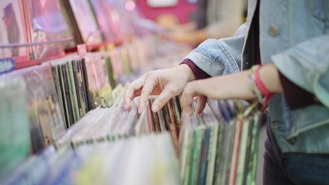 Young Woman Choosing Vintage Vinyl LP In Records Shop