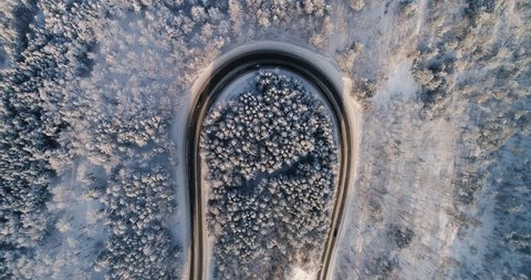 The road in the winter. A sharp turn on a winter road. The road in a snowy forest. Winding mountain road. top view. Aerial view. 