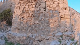 Closeup of ancient stone fortress wall. Old medieval fortification built in the XIV century. Capdepera Castle, Mallorca, Balearic islands, Spain. 4K footage, wide angle. Sunset, evening time