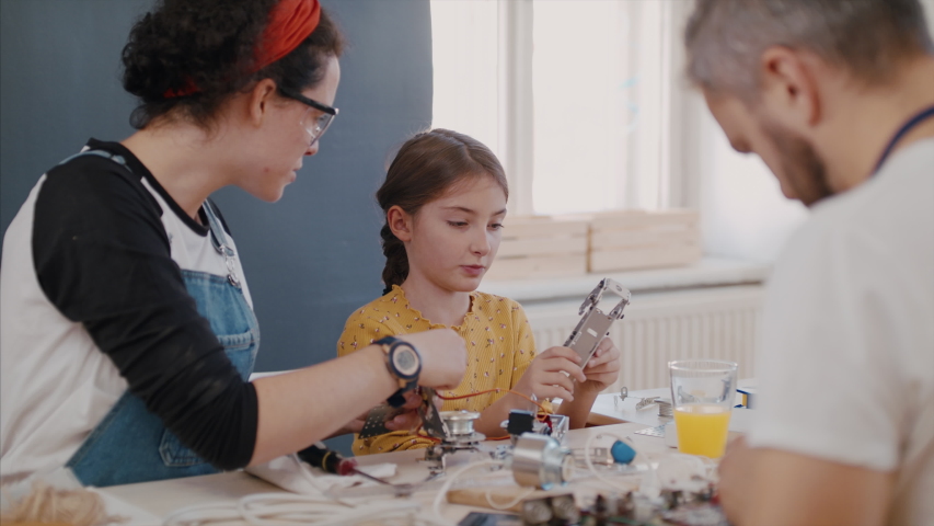 A group of people at repair cafe repairing household electrical devices. | Shutterstock HD Video #1044293308