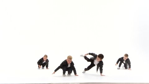 Boys are dancing a modern dance on the white background in black leather jackets and jeans