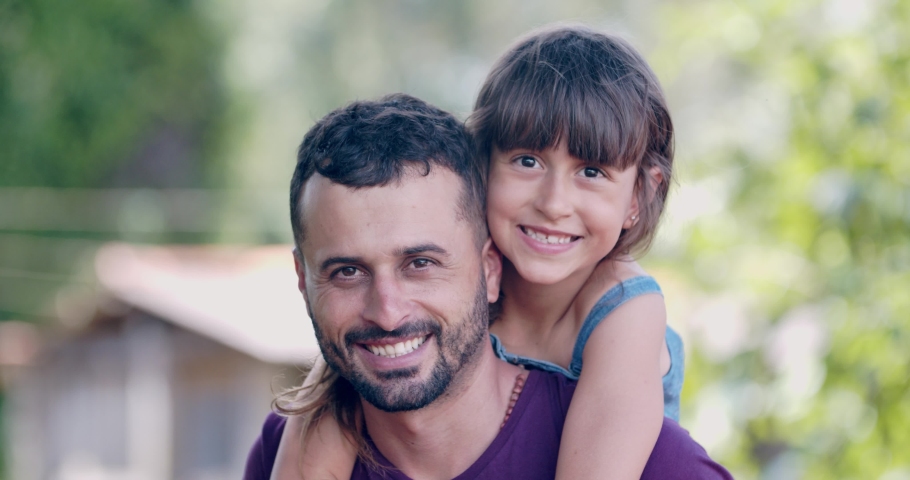 Brazilian little girl sitting on her fathers shoulders. 4K.
