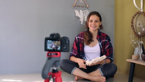 Cheerful young adult girl craft blogger recording online DIY video for the channel in social media.