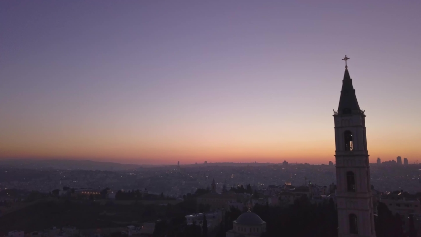 Aerial footage of a large church tower in old city Jerusalem during sunset