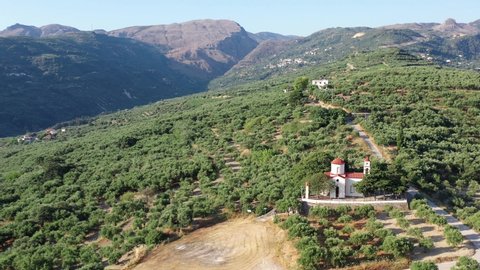 Greek countryside aerial video view from drone. Christian orthodox church near Voulgaro village.  It stands on  hill and is surrounded by olive groves. Dimos Kissamou, Chania prefecture, Crete, Greece