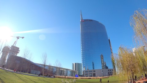 Milan, Italy - February 05, 2020: Walking on sunny winter day in the new public park called “Library of trees” in the new Porta Nuova business and residential district . Timelapse hyperlapse.