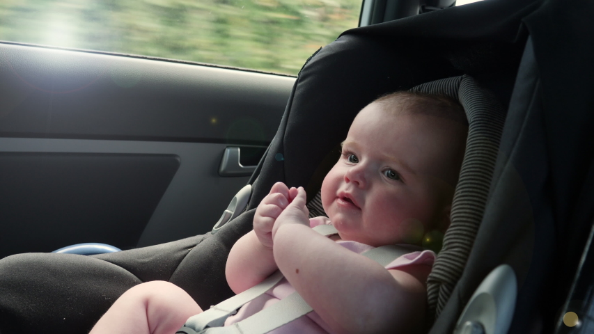 Baby travelling in a Car seat in the back of a vehicle. This child is safely strapped in witha seatbelt on. Slow motion Royalty-Free Stock Footage #1044319366