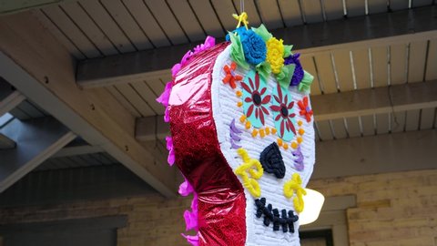 Sugar skull pinata hangs on wire, party for dia de los muertos background