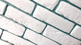 Tilted white brick wall video - textured pattern with green background.