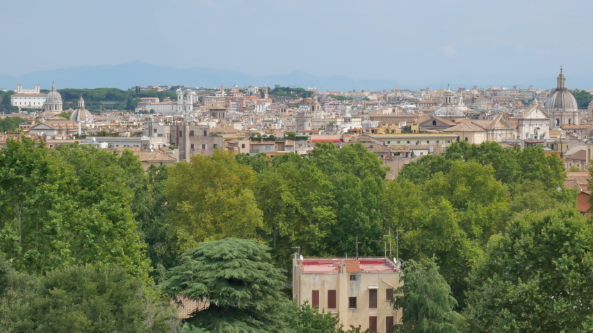 Old architecture and the sights in Rome in the sunny day. View from the hill, pan.