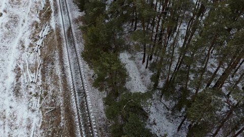 Top view at the wintry way rail road. Winter snow forest railway landscape. Forest railroad in winter snow scene.