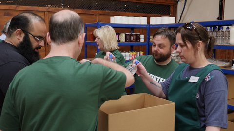 Foodbank volunteers help to sort tinned food and drinks for people in poverty and with social issues