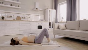 side view of pregnant woman exercising at home on fitness mat