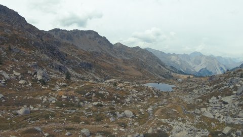 Panning footage of high mountains around the Lac Rond de Cristol in Massif des Cerces in the French Alps