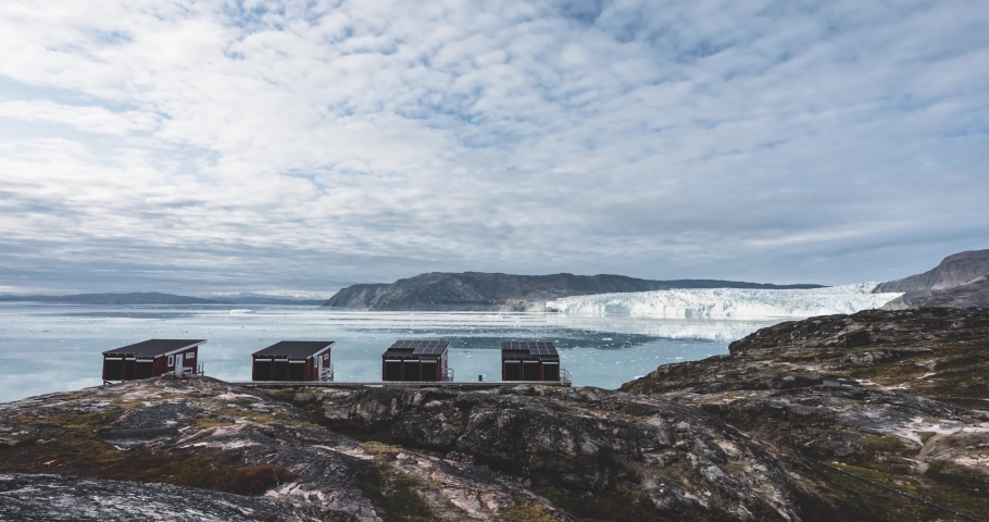 4k longtime moving Timelapse Video clip of Eqip Sermia Glacier Eqi glacier red huts in Greenland. Sunset and Sunrise during Midnight Sun. Called the calving glacier. Huge glacier wall of ice. 