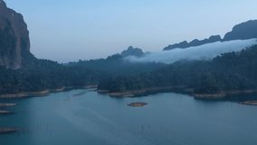 A drone flies through a fog. Video from drones on Lake Che Lan, breathtaking views of wild mountains and a blue lake, Thailand, Phuket's protected areas, rainforests, a trip to Thailand with a drone.