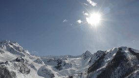 Aerial photography video. Snow-capped mountains. The ski resort. Tourism and rest. Krasnaya Polyana, Sochi. Clear, Sunny weather. Aibga.