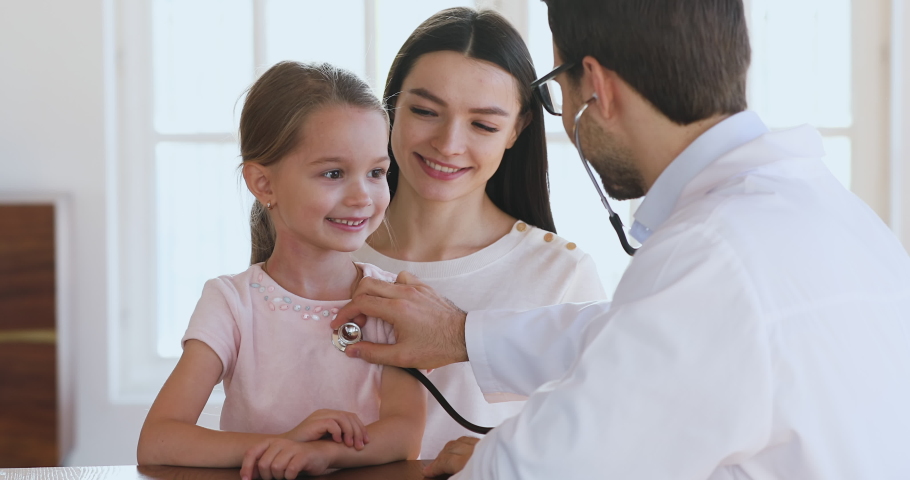 Male pediatrician hold stethoscope exam cute little child girl patient visit doctor with mom, paediatrician listen kid heartbeat do pediatric checkup in hospital, children medical health care concept | Shutterstock HD Video #1044436999