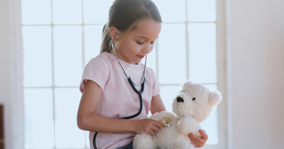 Cute healthy happy little child girl playing game as vet doctor concept holding stethoscope listening sick toy at home, funny preschool child pretending medical nurse treat teddy bear patient alone Royalty-Free Stock Footage #1044437080