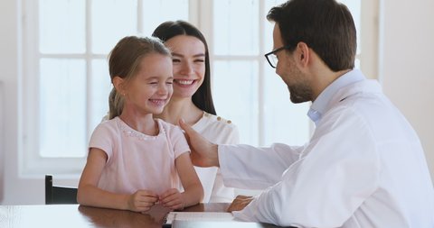 Happy cute little preschool girl give high five to male doctor pediatrician talking to trusting child patient mom at medical consultation, children health care treatment and pediatric checkup concept