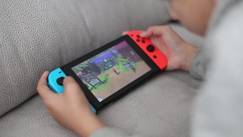 tel Aviv, Israel - January 01, 2020: close-up children's hands holding a portable console Nintendo switch, a boy playing pokemon