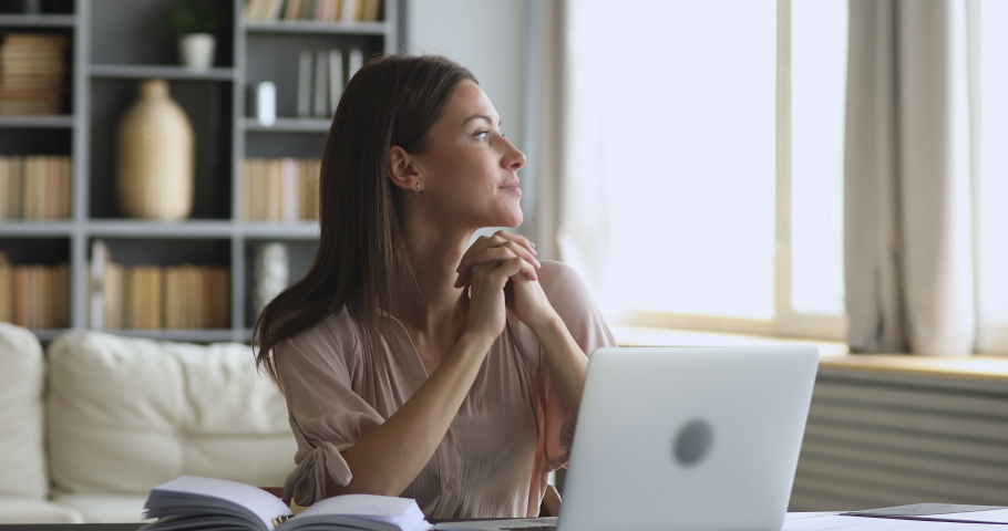 Thoughtful smiling young woman writer professional take break from work looking away dreaming thinking or future opportunities search new creative ideas sit at home office table with laptop computer Royalty-Free Stock Footage #1044455014