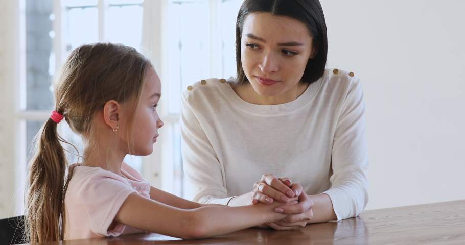 Caring young mother children psychologist hold hand talk comforting sad kid girl child daughter help with problem give psychological support in trust honest conversation at therapy session concept Royalty-Free Stock Footage #1044455044