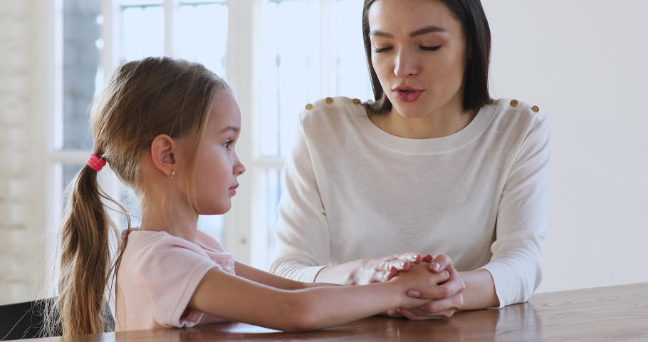 Caring young mother children psychologist hold hand talk comforting sad kid girl child daughter help with problem give psychological support in trust honest conversation at therapy session concept | Shutterstock HD Video #1044455044