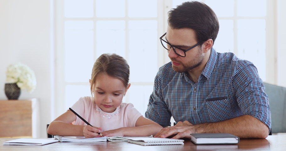 Adult dad or teacher and happy cute preschool school child girl daughter study together learn write give high five celebrate successful class finish homework, parent help child with education concept Royalty-Free Stock Footage #1044455047