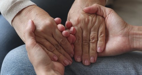 Young woman hold old female hands giving support concept, kind adult daughter caregiver helping senior mature mother grandparent patient, elder people respect, comfort and care concept, close up view