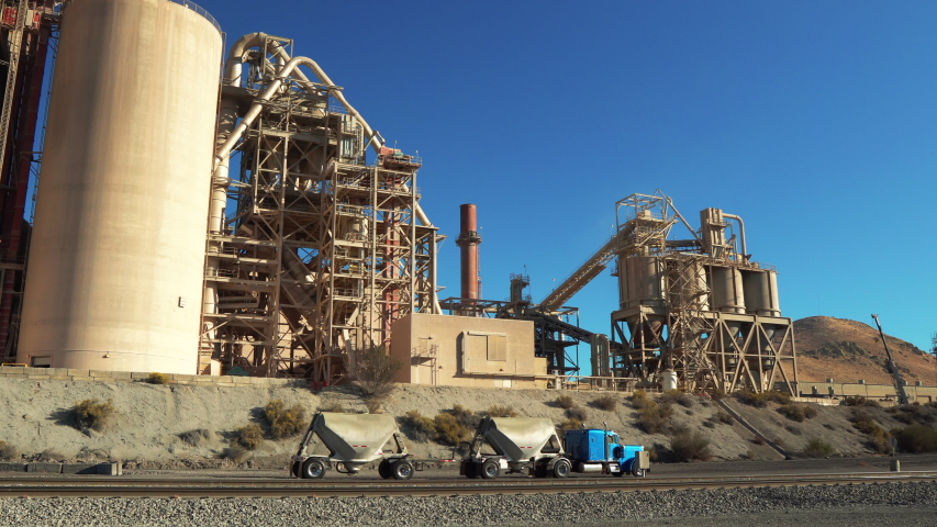 Cement truck slowly driving by Lehigh Factory in Monolith, California