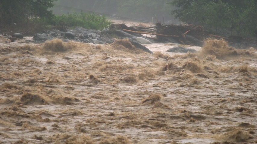 Fast flowing raging river. Soil and mud is moving towards down. After strong rain. Giant roiling brown muddy water. Foamy stream dangerous wild brook. Swollen boiling creating. Damage environmentally. Royalty-Free Stock Footage #1044477793