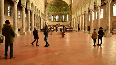 Ravenna, Italy, December 2019. Footage inside the Apollinare basilica in the classroom. Tilt movement from bottom to top in the direction of the apse. Many people visiting.