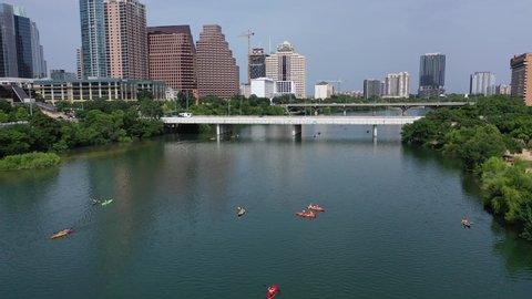 Kayakers on lake in Austin Texas, aerial view with pan up to reveal skyline