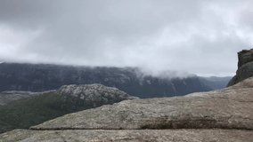 Breathtaking video of Preikestolen pulpit rock captured during rainy summer day in Norway. High mountain landscape in hazy weather. View from Preikestolen mountain in Scandinavian Europe
